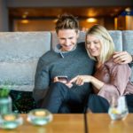 Digitale Gästekommunikation_Gäste stöbern auf ihrem Smartphone in der digitalen Gästemappe von Gastfreund